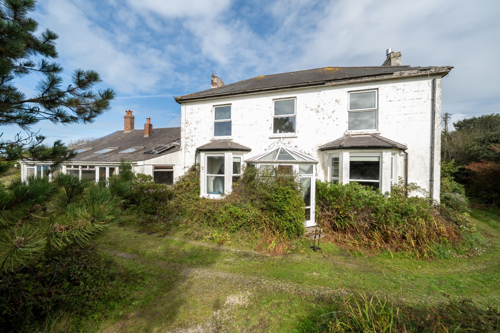 Lot: 47812 - FORMER CAPTAINS HOUSE PLUS THREE-BEDROOM BUNGALOW SET IN OVER 8.5 ACRES OF LAND WITH COUNTRYSIDE AND SEA VIEWS - Front elevation of main house and sun lounge including part of the attached bungalow accommodation to the far end